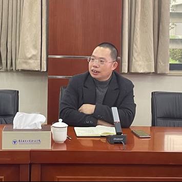 桌子上放着笔记本电脑前的男人低可信度描述已自动生成